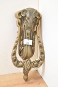 A cast brass door knocker of classical style having ram and foliage decoration, L24cm