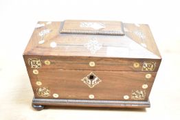 A 19th century rosewood tea caddy of sarcophagus form, supported on bun feet, decorated with pearl