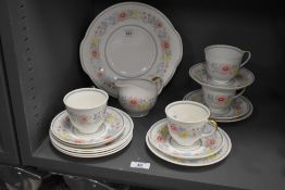 A Susie Cooper bone china tea service, having gilt handles and decorated with floral patterns on a