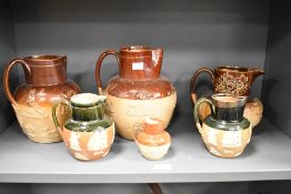 A Doulton Lambeth ceramic pitcher having shaped spout and decorated with windmill and hound