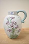An early 20th century Danesby ware ceramic jug, decorated having blue bell reliefs on an eggshell