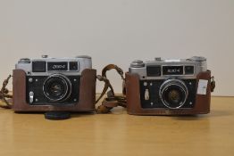 Two FED-4 35mm rangefinder cameras, both with FED 53mm f2.8 lens and brown leather case and strap.