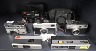 Eight cameras. A Kodak 277X, a Kodak Instamatic 33, a Photosport Highlight tele, a Kodak