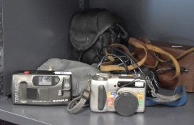 An Olympus Trip MD2 camera and a Sony Mega Movie EX digital camera