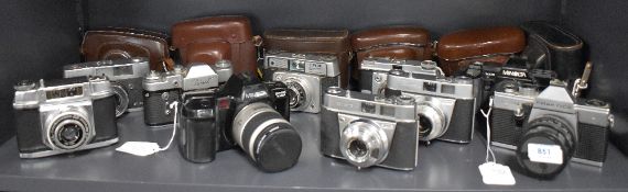 A group of ten cameras. A Mamiya EE Merit, A Zenit 3M, two Ilford Sportsman, two Kodak Reinette, a
