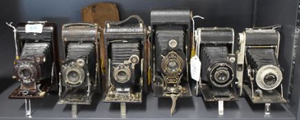 A group of six folding cameras. Includes a Soho Cadet, A Kodak Pocket No1 Series II, a Kodak No1