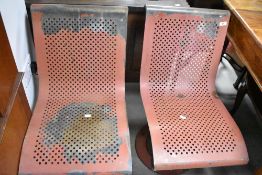 A pair of metal seats, possibly railway station or bus stop related