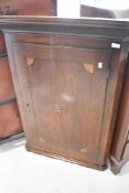 A 19th Century oak corner cupboard having inlaid decoration to door, height approx. 104cm