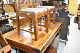 A modern hardwood dining table and two chairs