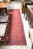 A vintage Afghan/Bokhara style carpet runner, approx 297 x 79cm