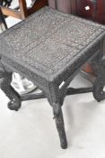 An Asian carved occasional table having reptilian decoration and elephant supports, approx. 46 x