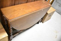 A traditional mahogany dining table having narrow top and turned gate legs, width approx. 126cm