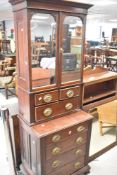A 19th Century Regency style mahogany cabinet of narrow proportions having mirrored door over two