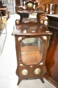 A traditional mahogany French vitrine style desplay cabinet having figural enamelled and brass style