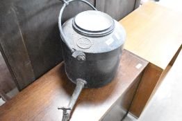 An Antique cast iron fireside kettle with hanger and extended spout with tap