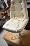 A vintage swivel dining or office chair with button back vinyl upholstery and chrome frame