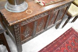A 19th Century oak kist having pie crust lid and carved panel decoration, with monogram SL, width