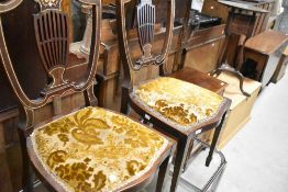 A pair of Edwardian mahogany salon chairs having inlaid decoration and overstuffed seats
