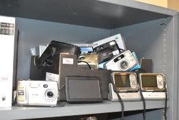 A collection of vintage cameras including a Kodak Easyshare DX4900, a Pentax ESPIO 7385, two