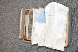 A wooden box containing a selection of table linen, a book commemorating the Coronation of Queen