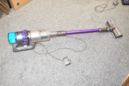 A Dyson Gen5 Detect Absolute cordless vacuum cleaner with charging cable.