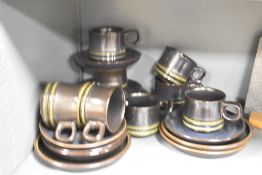 A vintage pottery tea set decorated having a green ripple base on a dark blue/green glaze ground, (