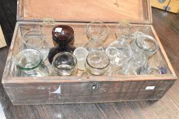 A sturdy wooden box containing a selection of glass vases etc.