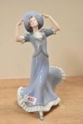An Art Deco style Czechoslovakian Royal Dux porcelain figurien of a female wearing blue dress and