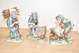 A group of three continental porcelain figurines depicting three old ladies, one on a grind stone,