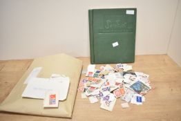 A Stanley Gibbons Swiftsure expanding stamp album partially filled and an envelope containing a