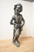 A large continental cast resin figure depicting an armed male leaning up against a tree, signed R,