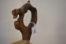 A hand carved walking stick with a terrier and hare carved in a loop 130cm approx