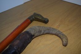 Two walking sticks measuring approximately 94cm long one with a brass dogs head and the other a rams