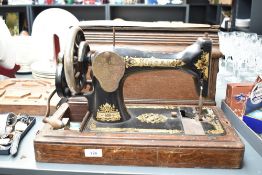 A Singer sewing machine with original oak cover case, w26cm