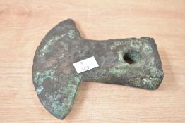 A bronze axe head believed to be pre Columbian Ecuadorian, having flared head and square shaft,
