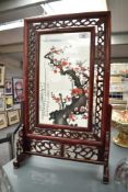 A 20th century Chinese swivel fire screen having a carved geometrical border, h58cm