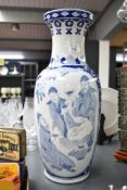 A blue and white vase decorated in the Chinese taste depicting scenes of palace life within a floral