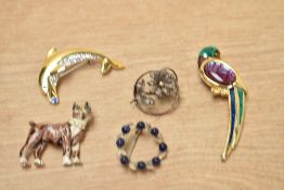 A small collection of costume brooches, comprising an enamelled and paste set dog, a paste and shell