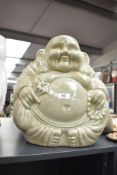 A ceramic Buddha sculpture in sitting position clutching onto his money bag, h38cm