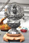 Asian School: A 20th century Buddha sculpture having multiple arms and raised on a wooden base,