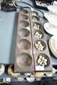 A African/Eastern style figural games board having 12 circular bowls, L51cm