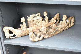 Two wooden tribal sculptures of men in boats, L53cm