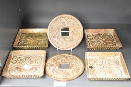 Two circular electrum cash-form appliques, w13.5cm, sold together with 4 trays, (6)