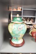 A Chinese style vase of lobed form having cover and decorated with floral patterns, raised on a