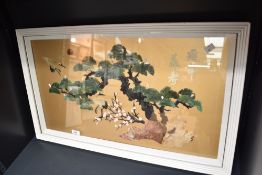 A decorative 20th century Chinese carved stone sample artwork, rocky outcrop with tree, blossoms and