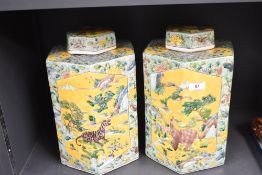 A pair of Chinese style tea caddies with covers, decorated with wildlife and landscape scenes,