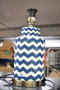A modern eye catching ceramic table lamp, of cylindrical form with repeating blue zigzagged