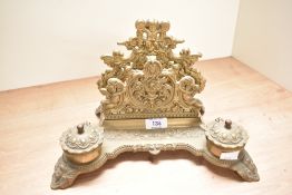 A 20th century brass desk tidy having inkwell and letter holder decorated with cherubs and
