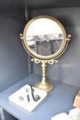 A brass dressing table mirror raised on a circular base, h44cm, sold together with a Guinness