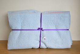 An antique Durham quilt in vibrant rose pink and baby blue cotton, showcasing the regional